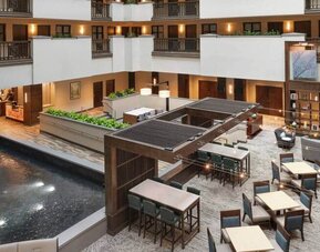 Overhead zoomed out view of common lobby area in center of hotel, a place to meet, eat, work.