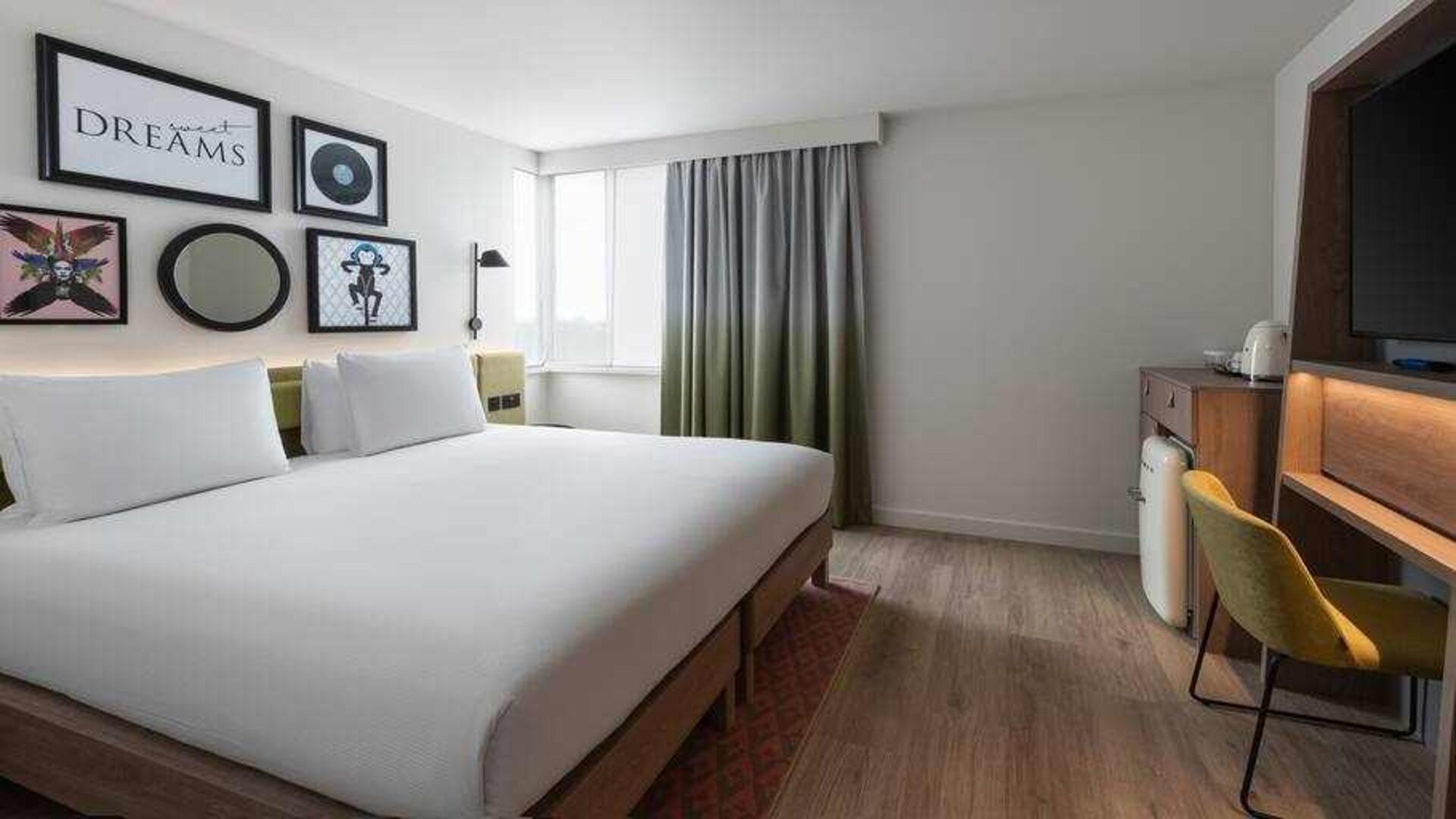 Bright king guestroom with desk at the Hampton by Hilton London Ealing.