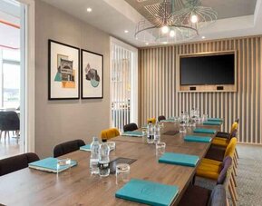 Small meeting room with TV screen at the Hampton by Hilton London Ealing.
