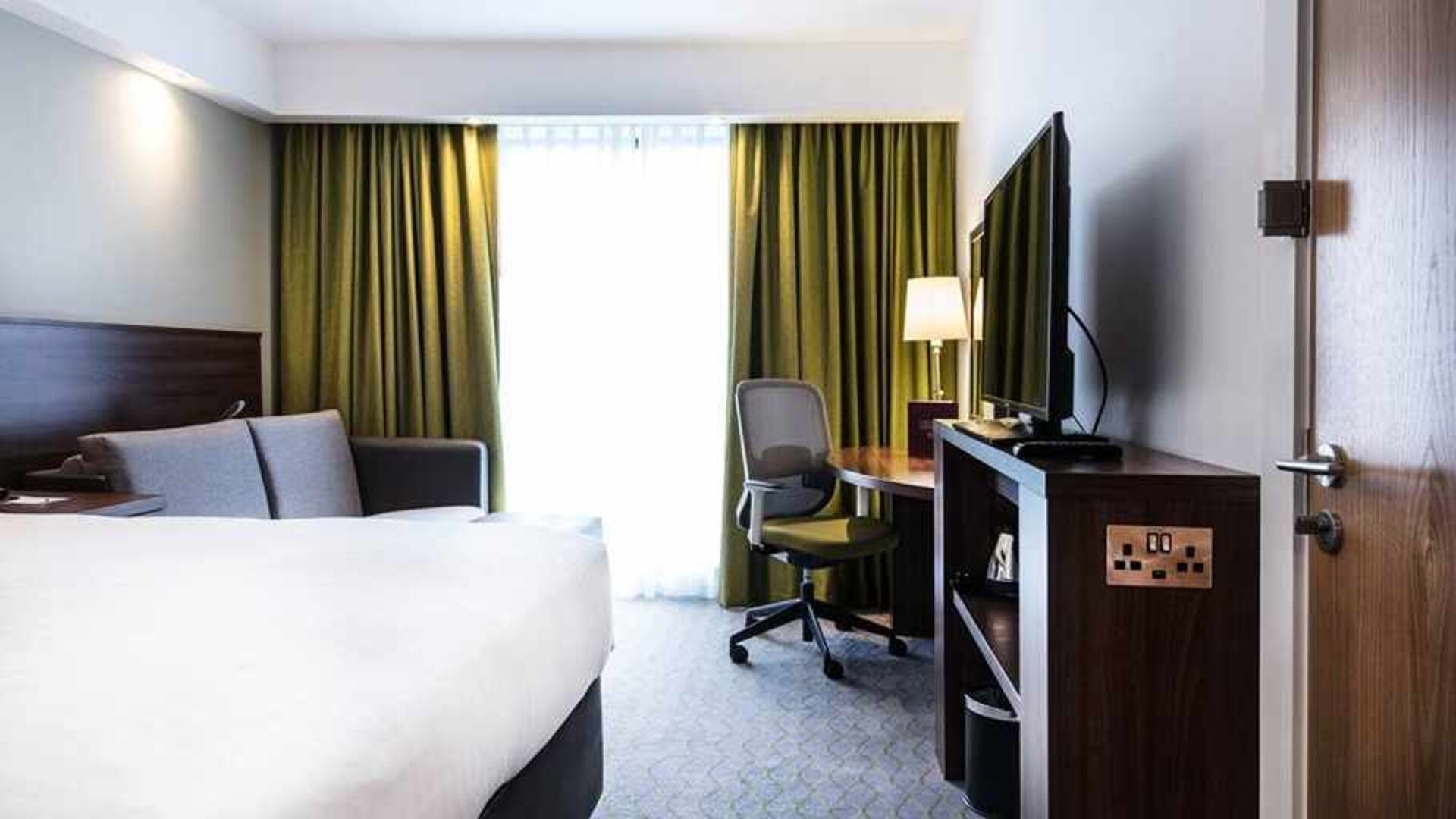 spacious king room with work area and lounge at Hampton by Hilton Exeter Airport.