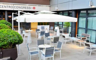 Outdoor terrace with sun umbrellas, chairs and tables at the Hilton Garden Inn Milan North.