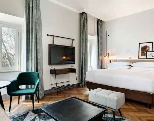 Spacious king bedroom with desk and TV screen at the DoubleTree by Hilton Rome Monti.