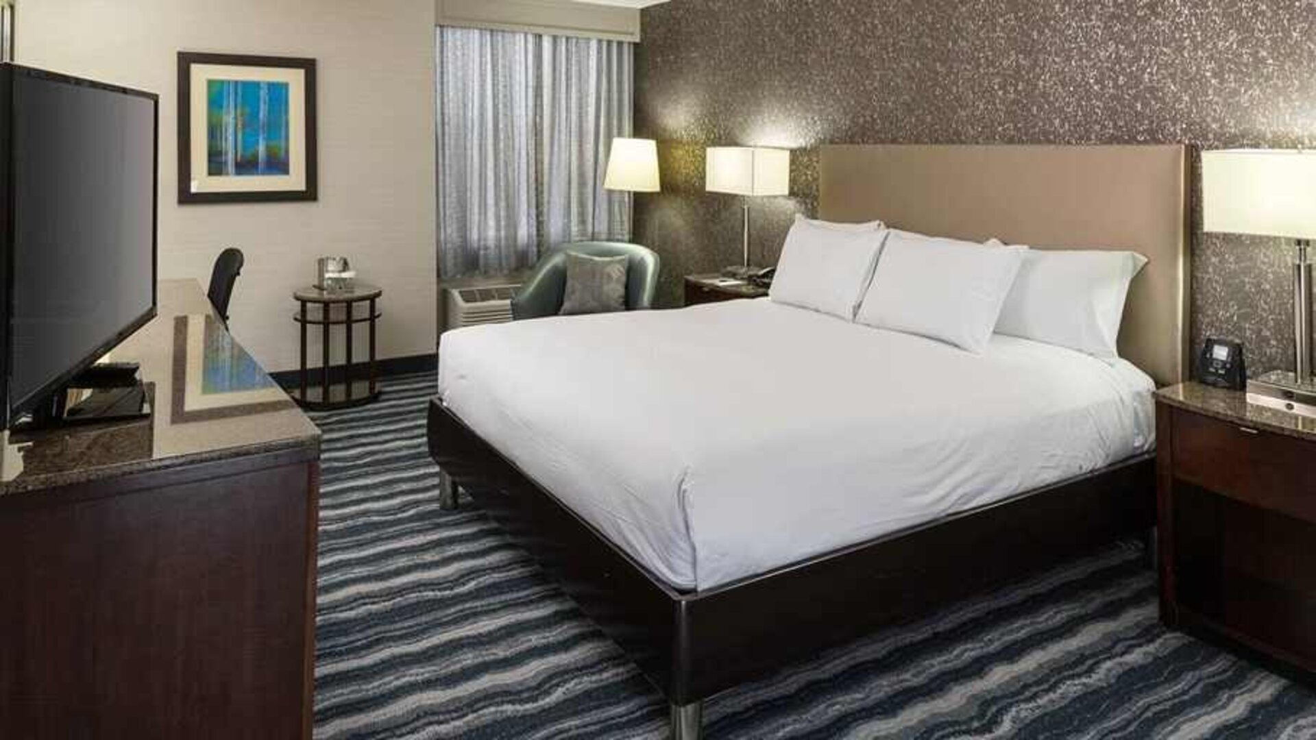 Comfortable king room with TV and work desk ideal for working remotely at DoubleTree by Hilton Hotel Wilmington.
