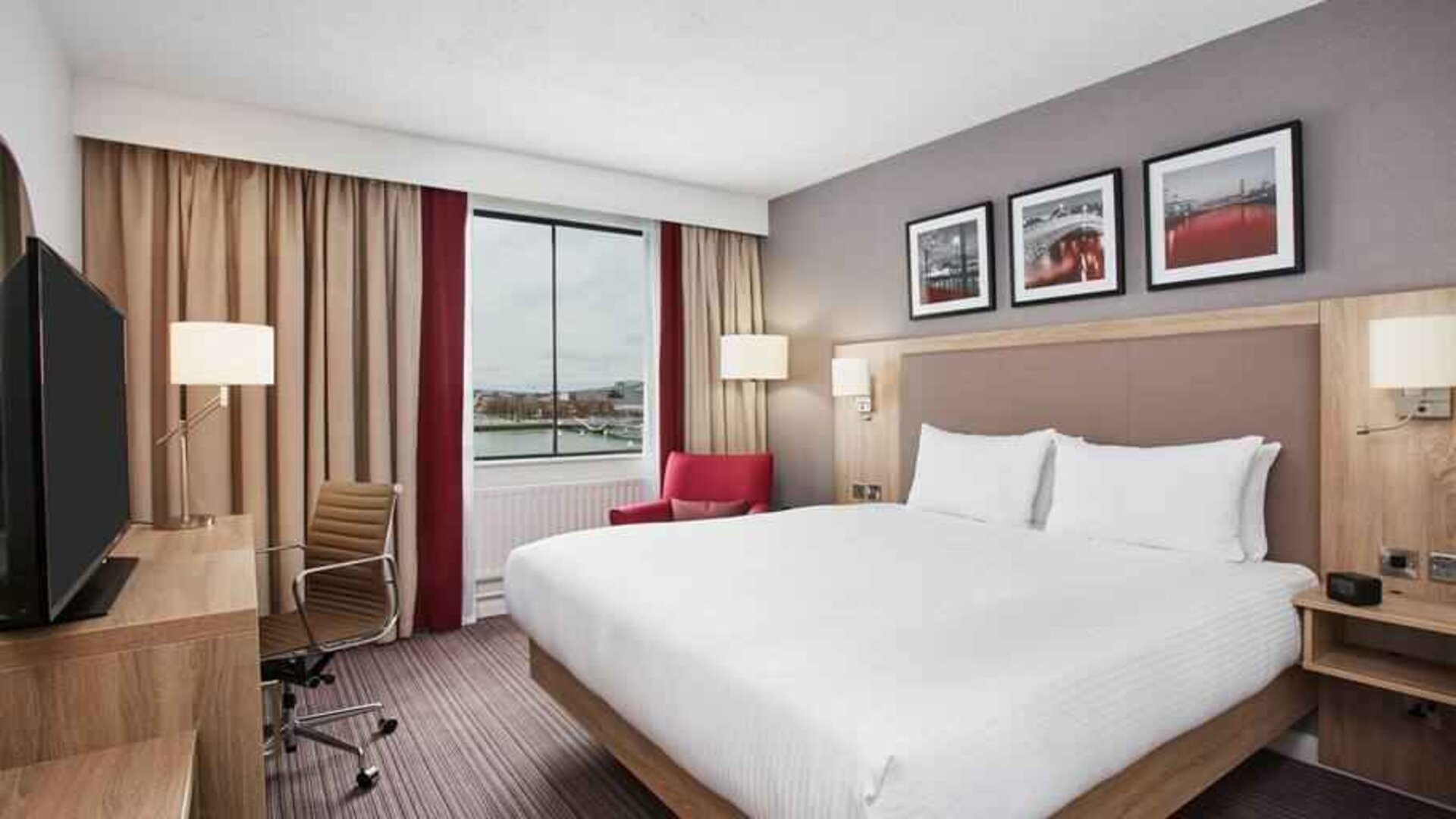 Bright king bedroom with desk and TV screen at the Hilton Garden Inn Dublin Custom House.