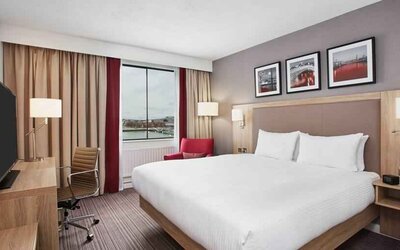 Bright king bedroom with desk and TV screen at the Hilton Garden Inn Dublin Custom House.