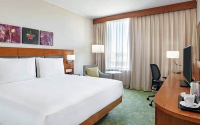 King-size bed with large desk area to work, dresser with large televsion on top.