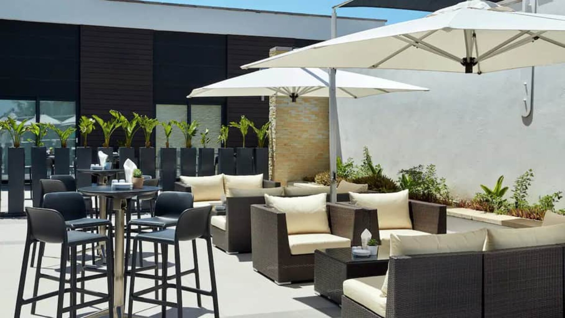 Round cocktail tables with seating for 4 or cabana lounge areas for seating for 4-6 people on outside hotel patio.