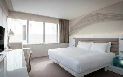 King bedroom with TV screen and desk at the Morrison, a DoubleTree by Hilton Hotel.