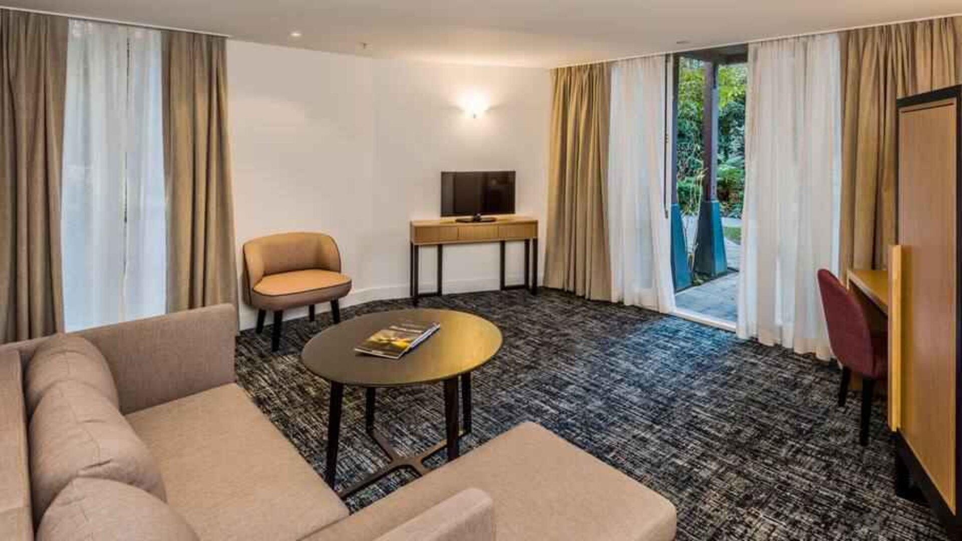 Suite living room with sofa and desk at the Morrison, a DoubleTree by Hilton Hotel.