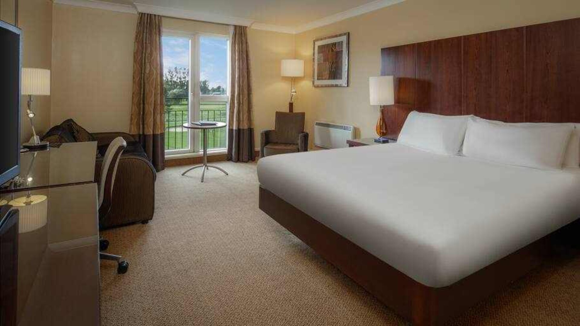 King bedroom with desk at the Hilton Belfast Templepatrick Golf & Country Club.