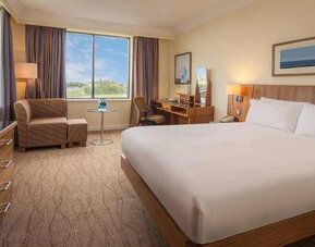 King bedroom with sofa, TV screen and desk at the Hilton Dublin Airport.