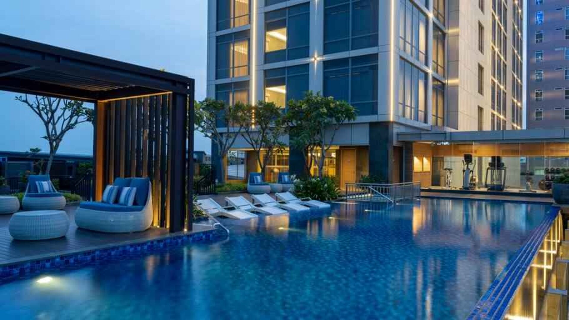 Beautiful outdoor pool area with lounges at the Hilton Garden Inn Jakarta Taman Palem.