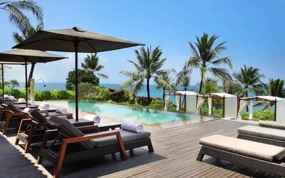 Outdoor pool with lounges at the Hilton Bali Resort.