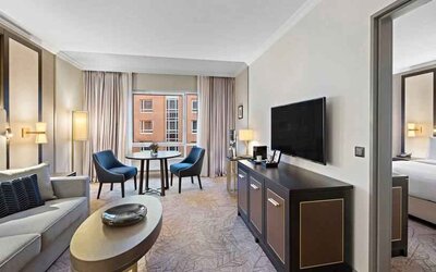 Spacious living room with working station by the window at the Hilton Munich City.
