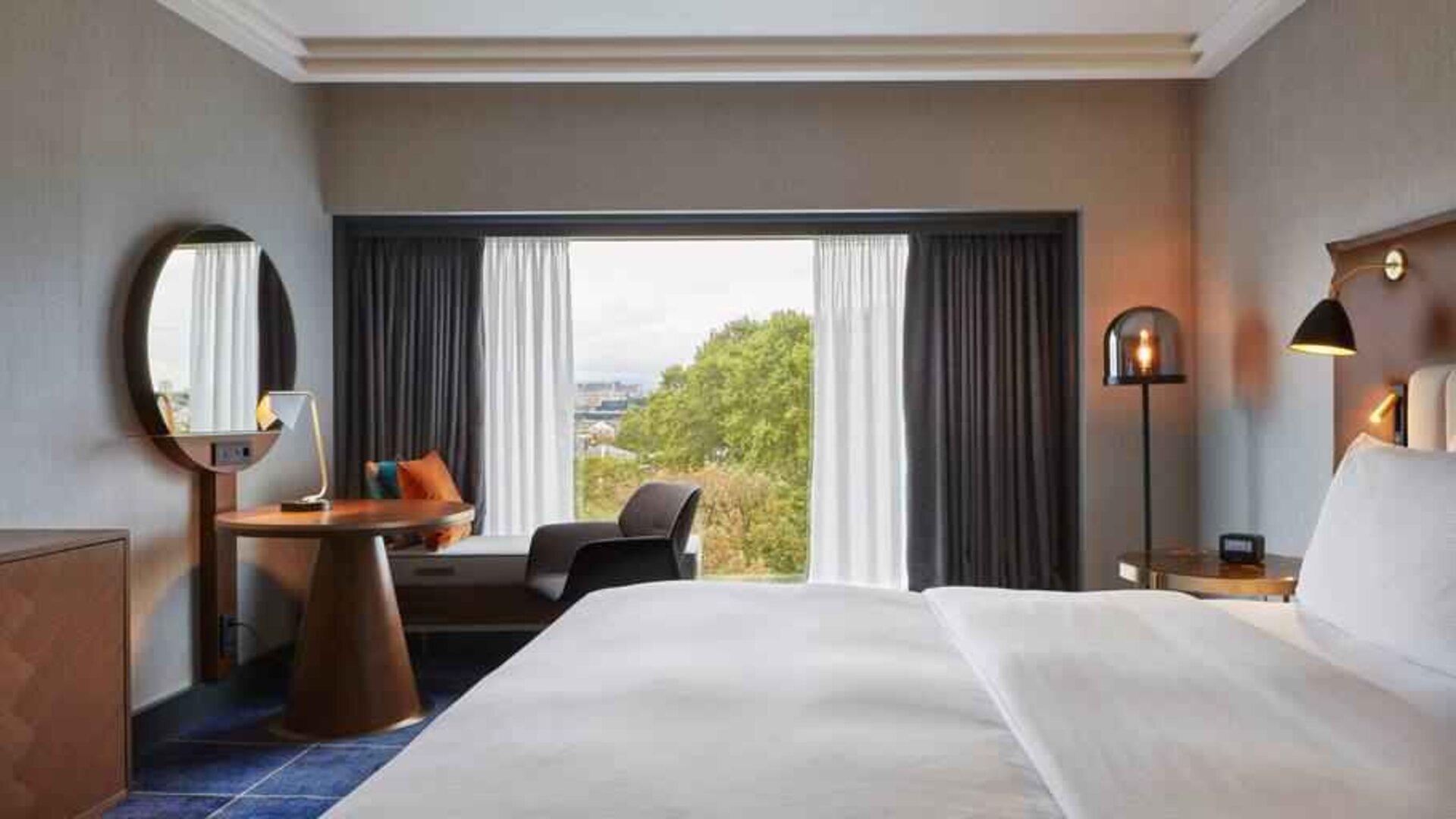 King guestroom with working station at the Hilton Frankfurt City Centre.