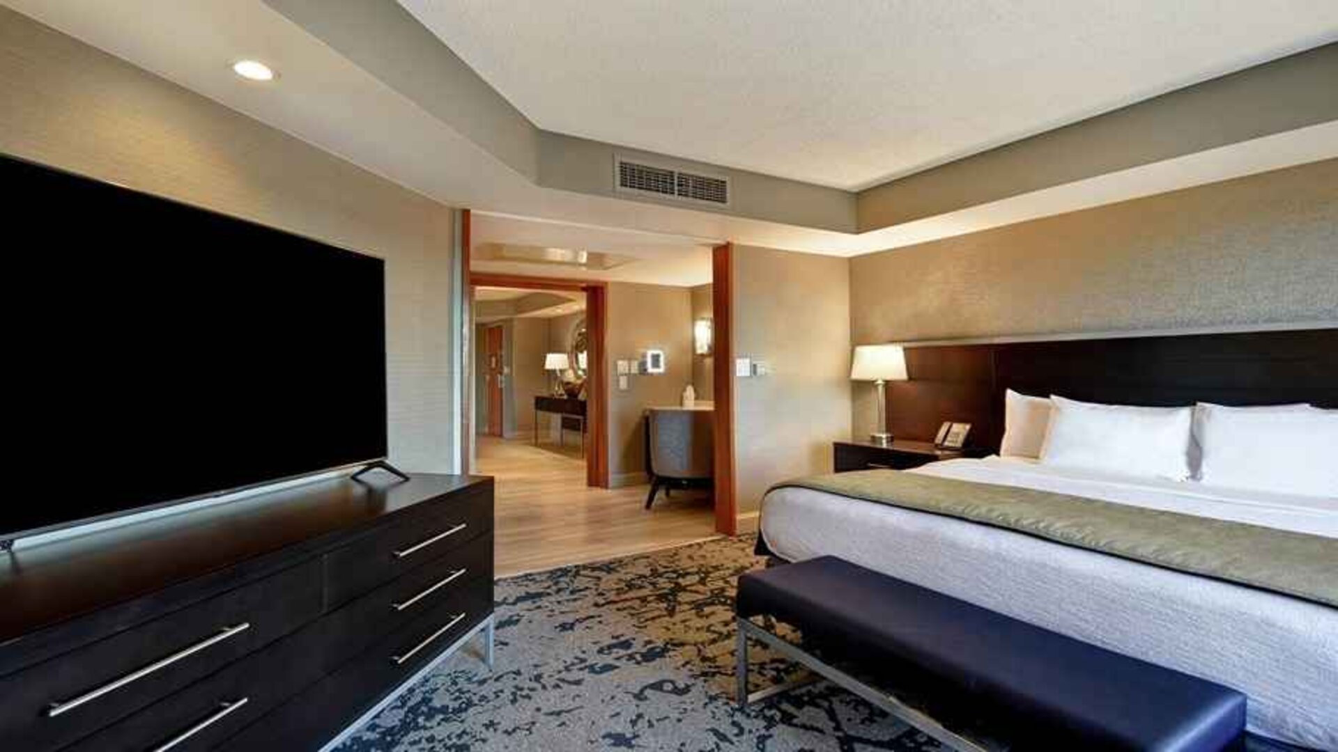 luxurious king suite with TV and lounge area at Embassy Suites by Hilton Raleigh Durham Research Triangle.