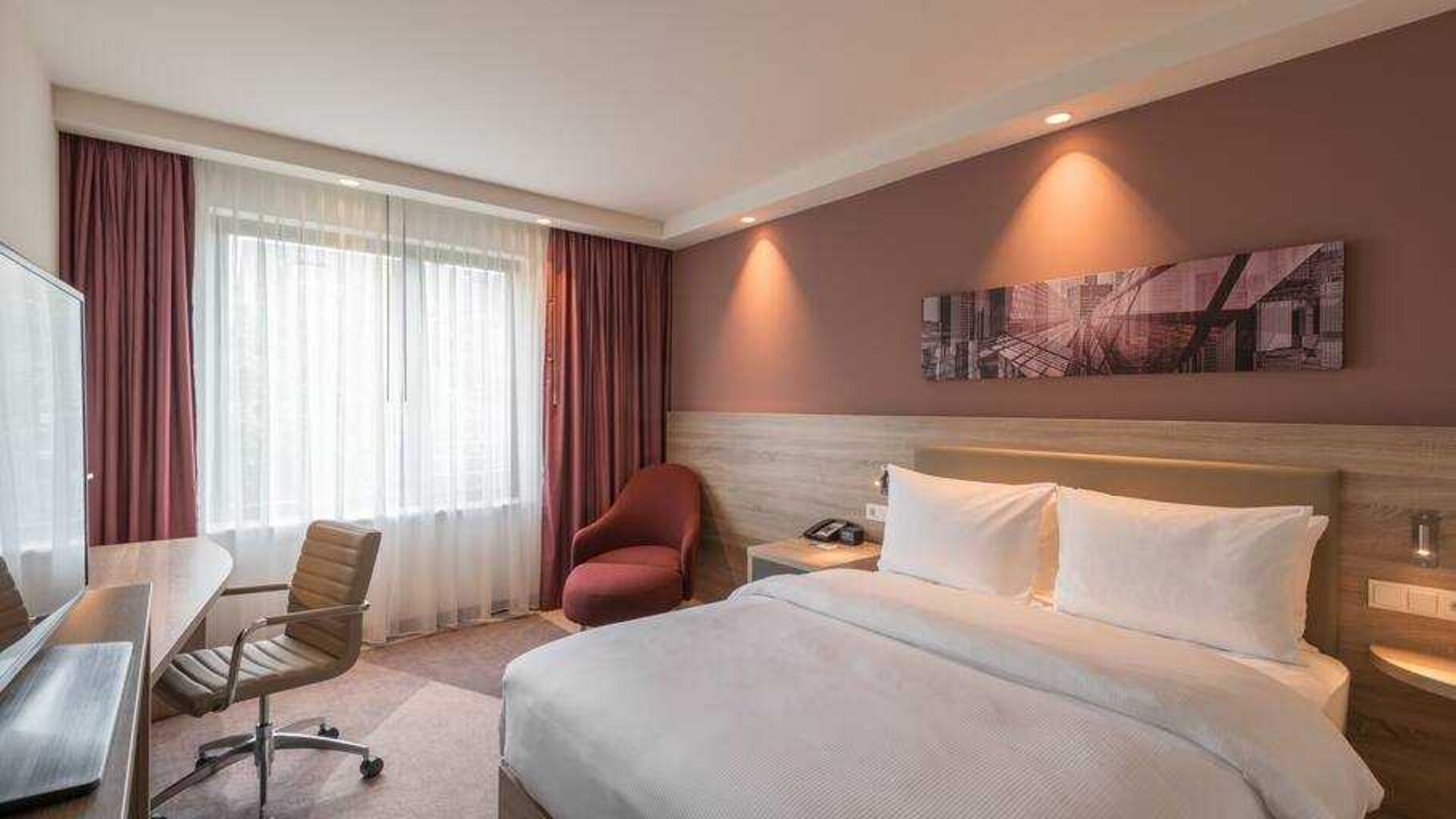 King guestroom with desk and window at the Hampton by Hilton Frankfurt City Centre East.