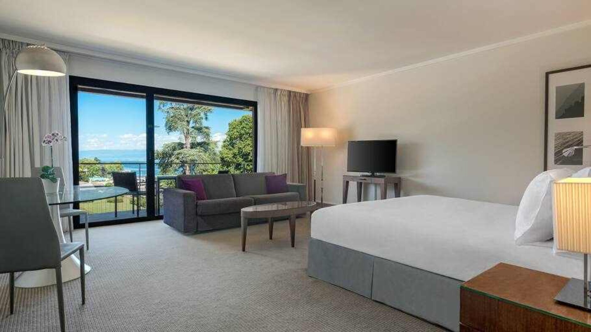 Hotel studio with sofa, TV screen and desk at the Hilton Evian-les-Bains.