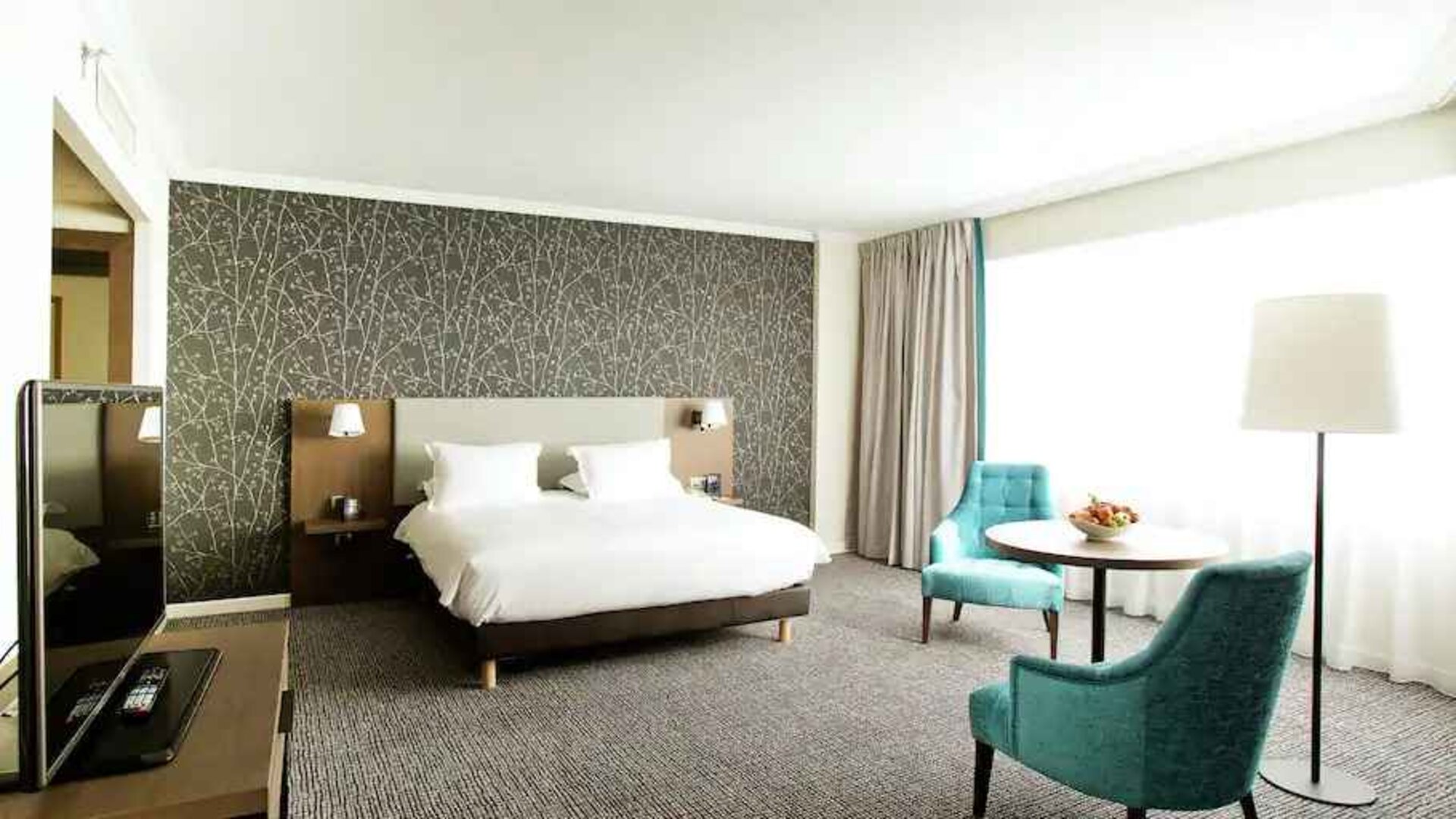 Bright queen room with working station at the Hilton Paris Charles de Gaulle Airport.