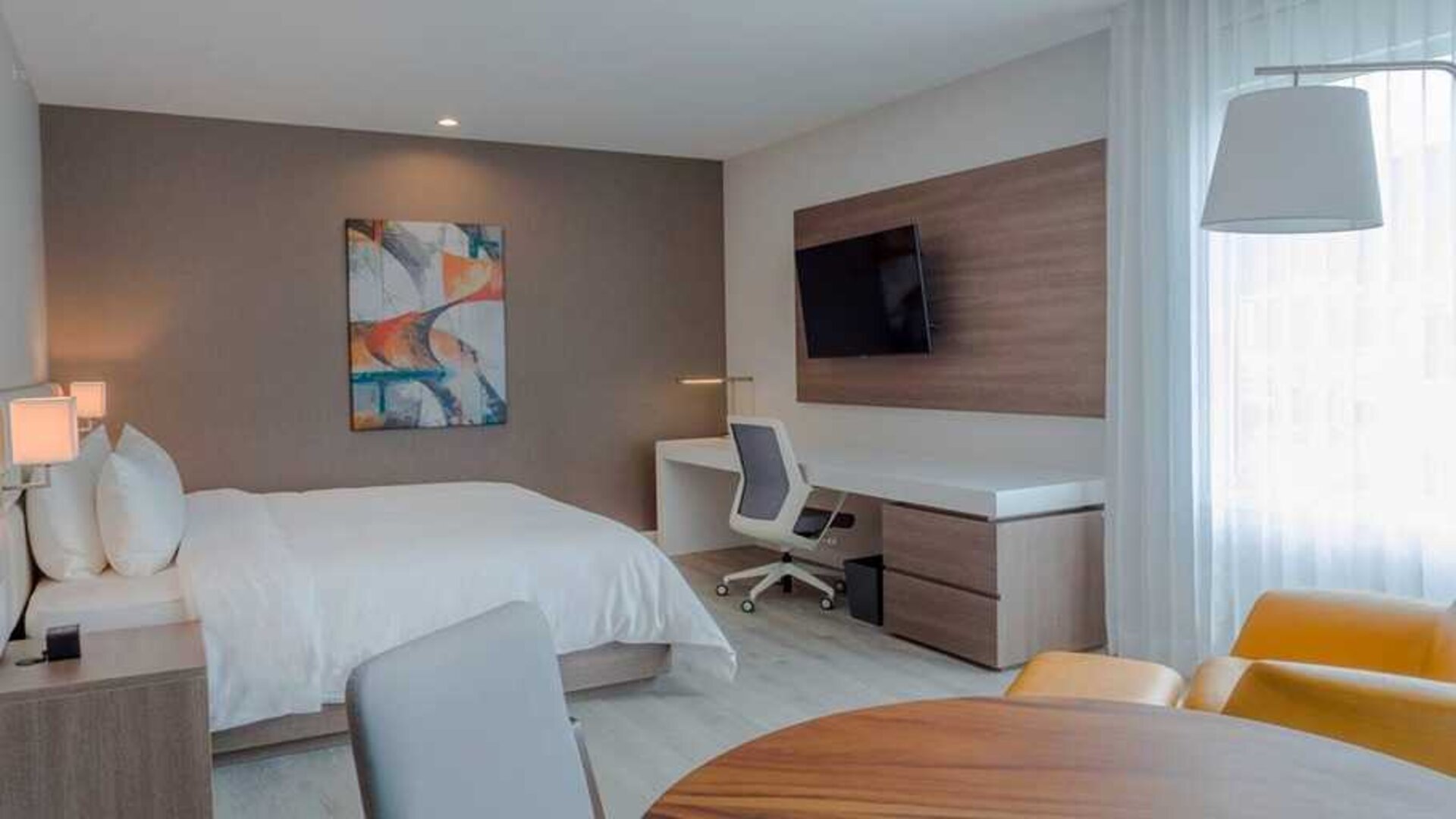luxurious king suite with TV, work desk, and dining area at Hilton Garden Inn Santa Ana San Jose.