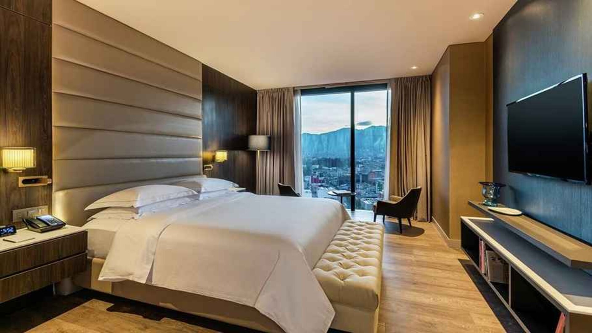 luxurious king room with TV, lounge area, and lots of natural light at Hilton Bogota Corferias.