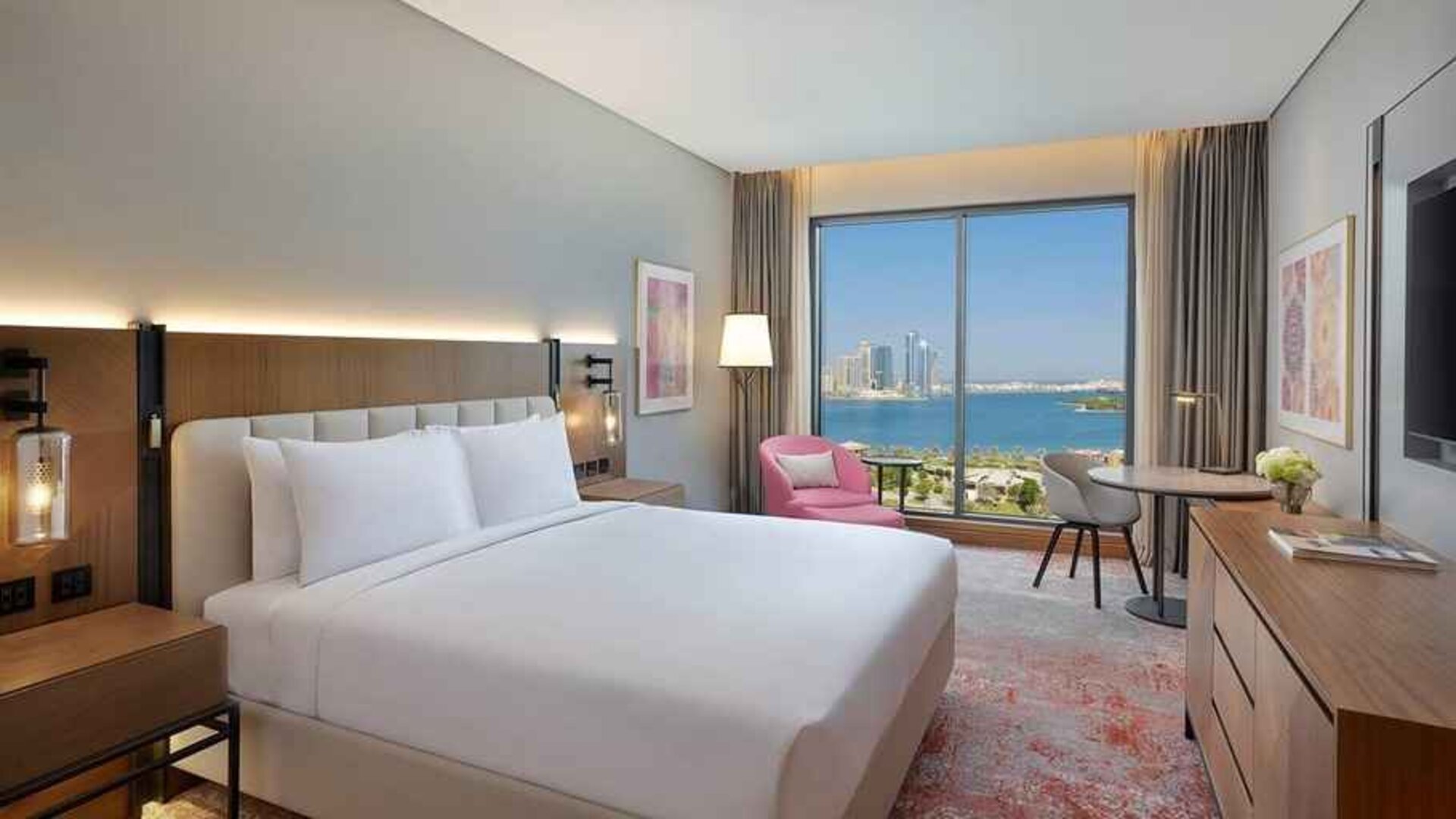 beautiful king room with work desk, TV, and water/city views at DoubleTree by Hilton Sharjah Waterfront Hotel & Residences.