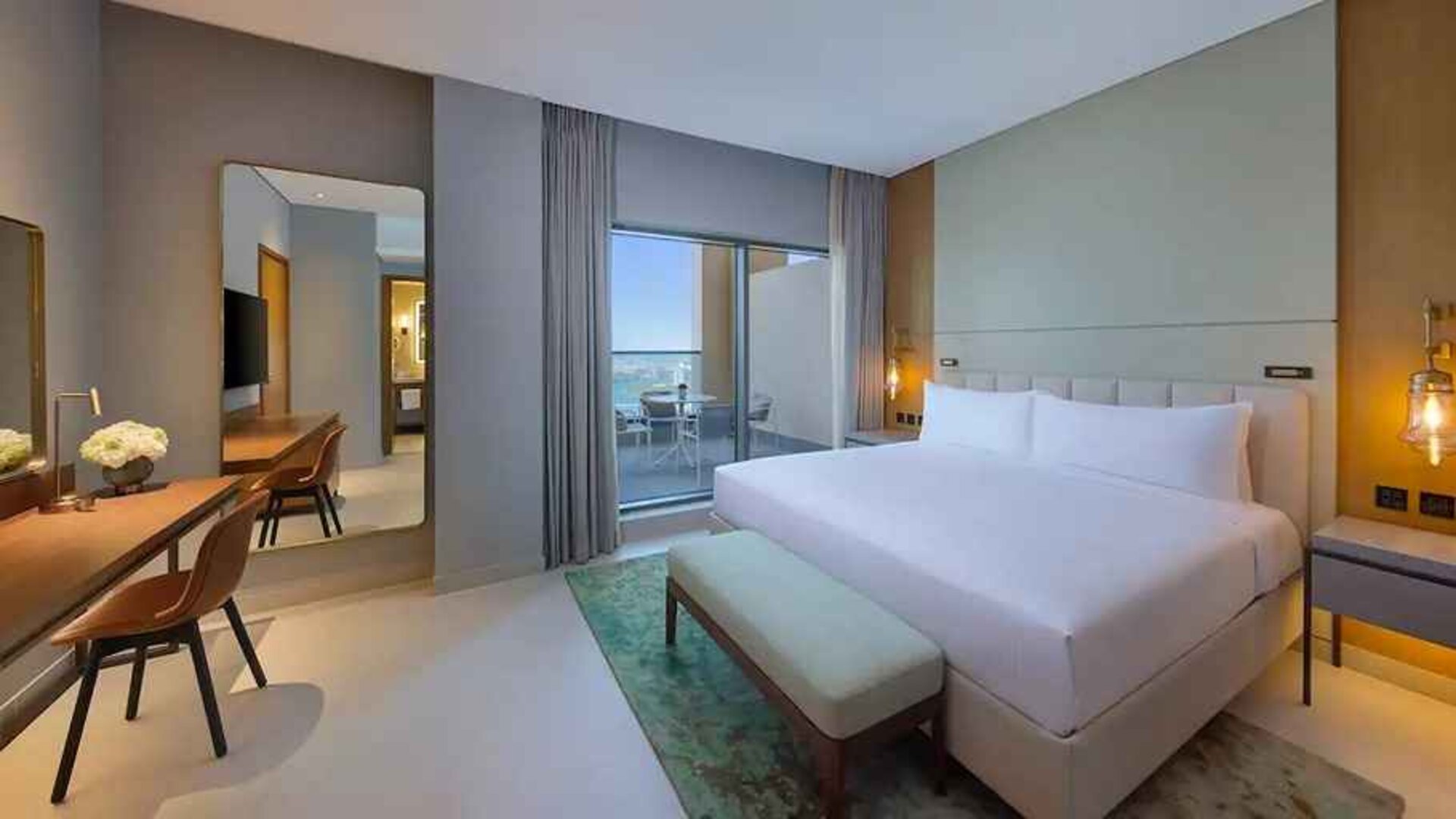 spacious king suite with work desk and lovely outdoor terrace at DoubleTree by Hilton Sharjah Waterfront Hotel & Residences.