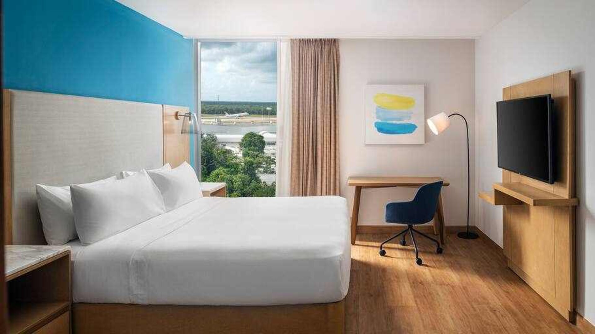 King bedroom with desk and TV screen at the Hilton Garden Inn Cancun Airport.