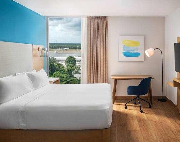 King bedroom with desk and TV screen at the Hilton Garden Inn Cancun Airport.