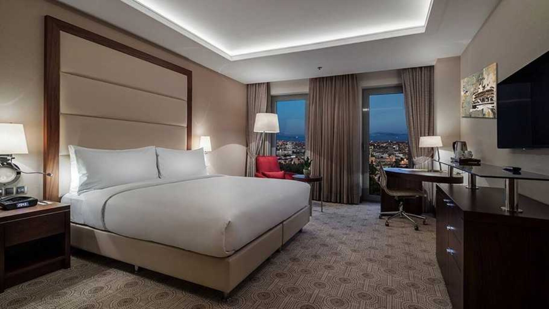 comfortable king bedroom with TV, desk, and chair at DoubleTree by Hilton Istanbul Topkapi.
