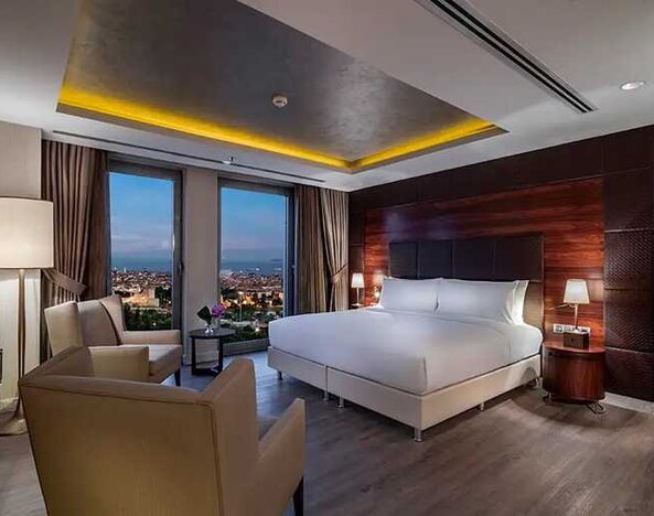 spacious king suite with TV, desk and chair, and lounge area at DoubleTree by Hilton Istanbul Topkapi.