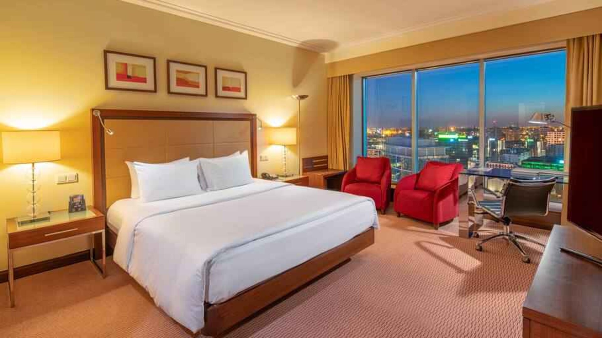 King bedroom with desk along the window at the Hilton Warsaw City.