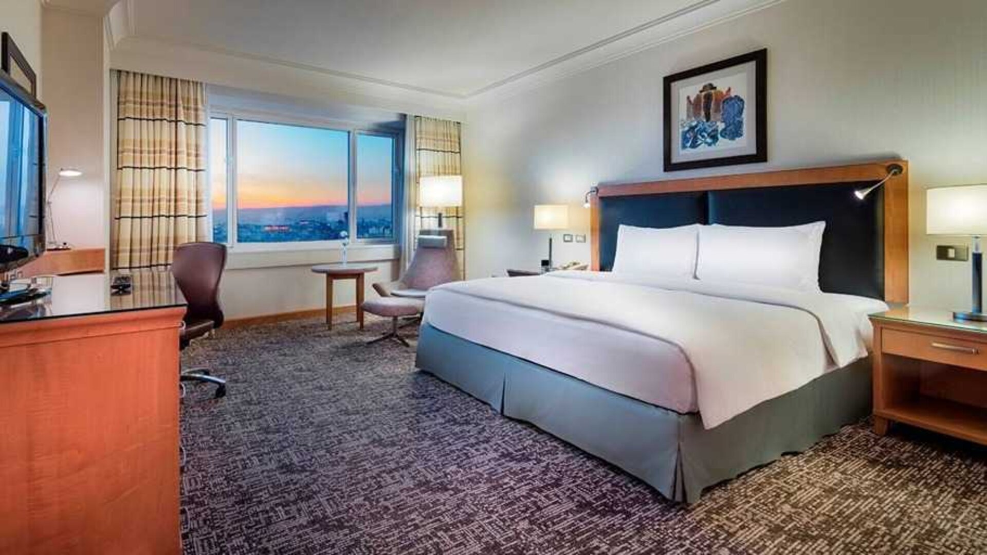 spacious delux king room with desk, chair, and TV at Adana HiltonSA.