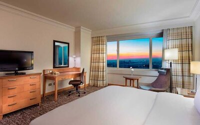 lovely king bedroom with TV, desk, and chair at Adana HiltonSA.