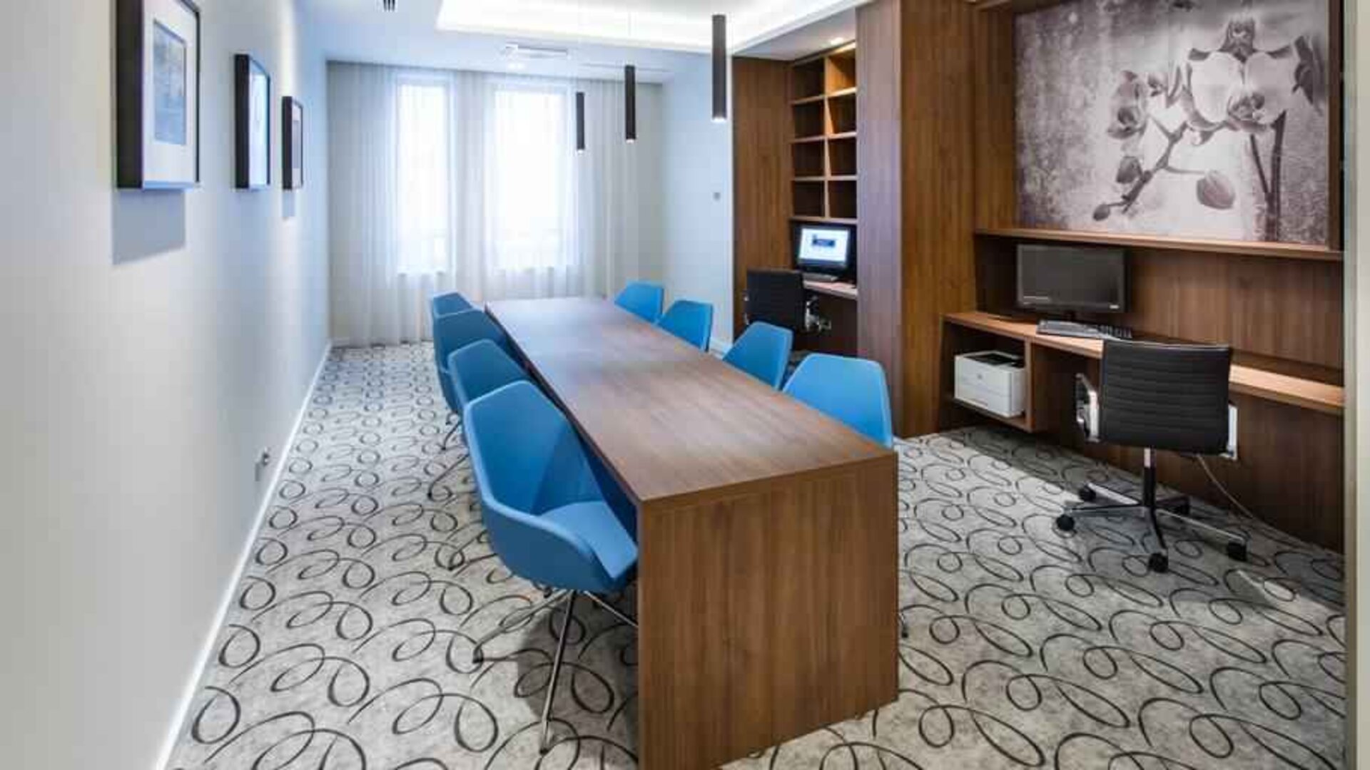 Business center with table, chairs, computer and printer at the Hampton by Hilton Gdansk Oliwa.