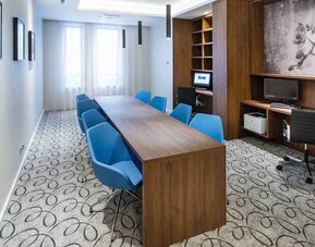 Business center with table, chairs, computer and printer at the Hampton by Hilton Gdansk Oliwa.