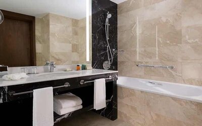 clean and spacious king bathroom with bath and shower at Hilton Astana.
