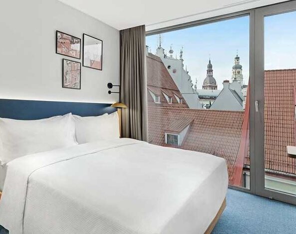 lovely delux king bedroom with chair and desk and lots of natural light at Hilton Garden Inn Riga Old Town.