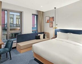 king room with chair, desk, and couch at Hilton Garden Inn Riga Old Town.