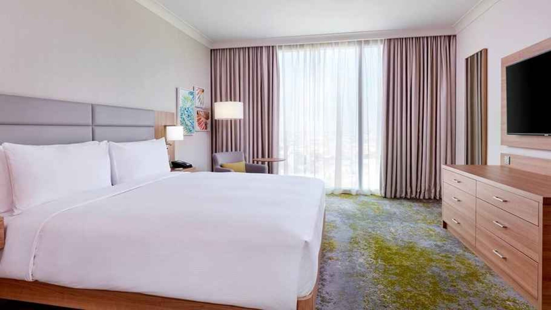 comfortable king room with TV and lots of natural light at Hilton Garden Inn Kuwait.