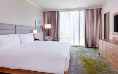 comfortable king room with TV and lots of natural light at Hilton Garden Inn Kuwait.