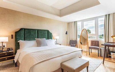 spacious king room with chair and desk and lots of natural light at Hilton Nicosia.