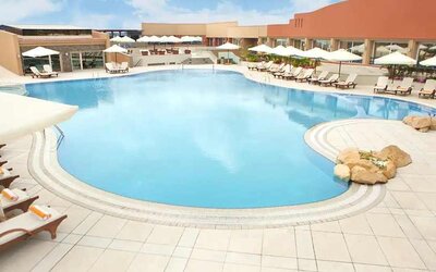 stunning outdoor pool with sunbeds and umbrellas at Hilton Alexandria Green Plaza.
