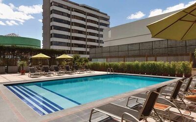 stunning outdoor pool with sunbeds and umbrellas at Hilton Colon Quito.