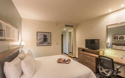 lovely king suite with TV, work desk, and chair at Hampton Inn & Suites by Hilton Salamanca Bajio.
