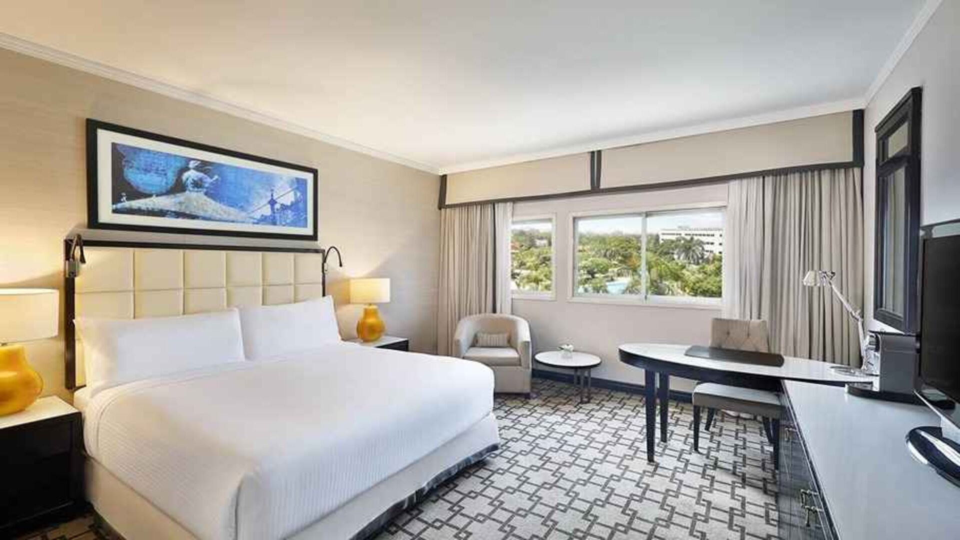 spacious king suite with TV, desk, chair, and couch at Hilton Cairo Heliopolis.