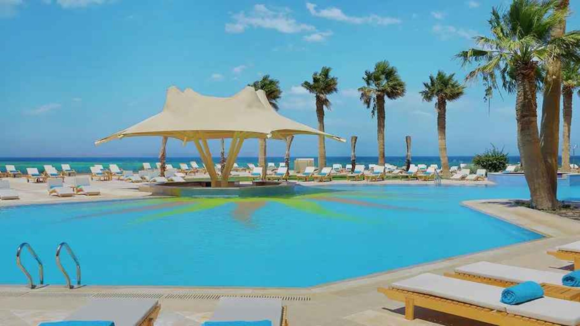 stunning outdoor pool with sunbeds and umbrellas at Hilton Hurghada Plaza.