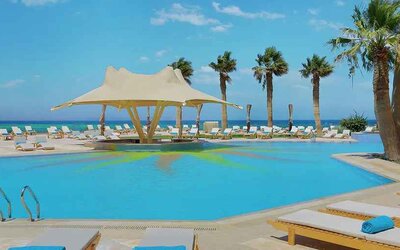stunning outdoor pool with sunbeds and umbrellas at Hilton Hurghada Plaza.