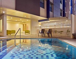 lovely outdoor pool with seating area at Hampton by Hilton Vadodara-Alkapuri.