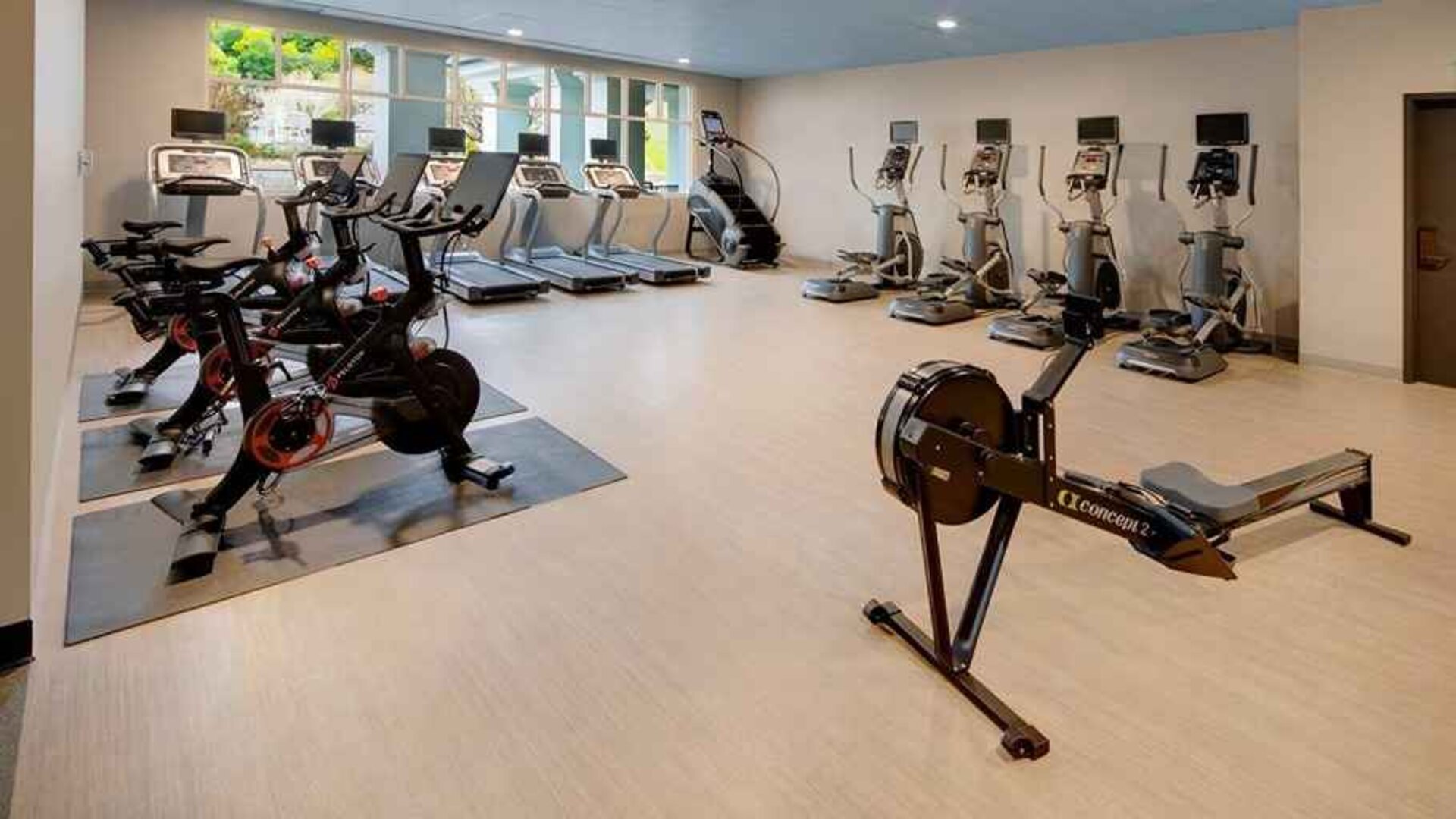 well-equipped fitness center with natural light at Embassy Suites by Hilton San Rafael Marin County.